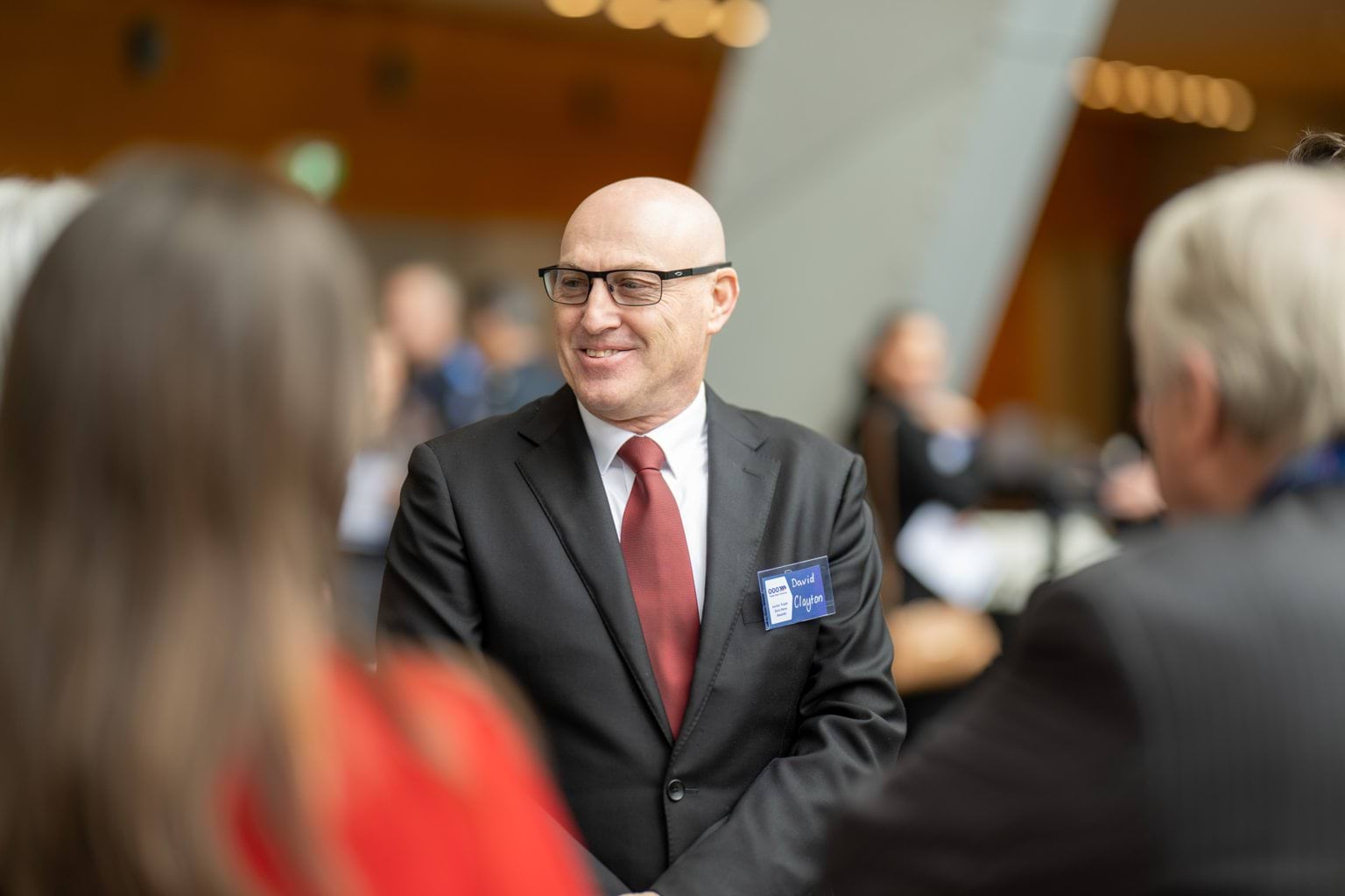 Gentleman talking to a group of people with their backs to the camera