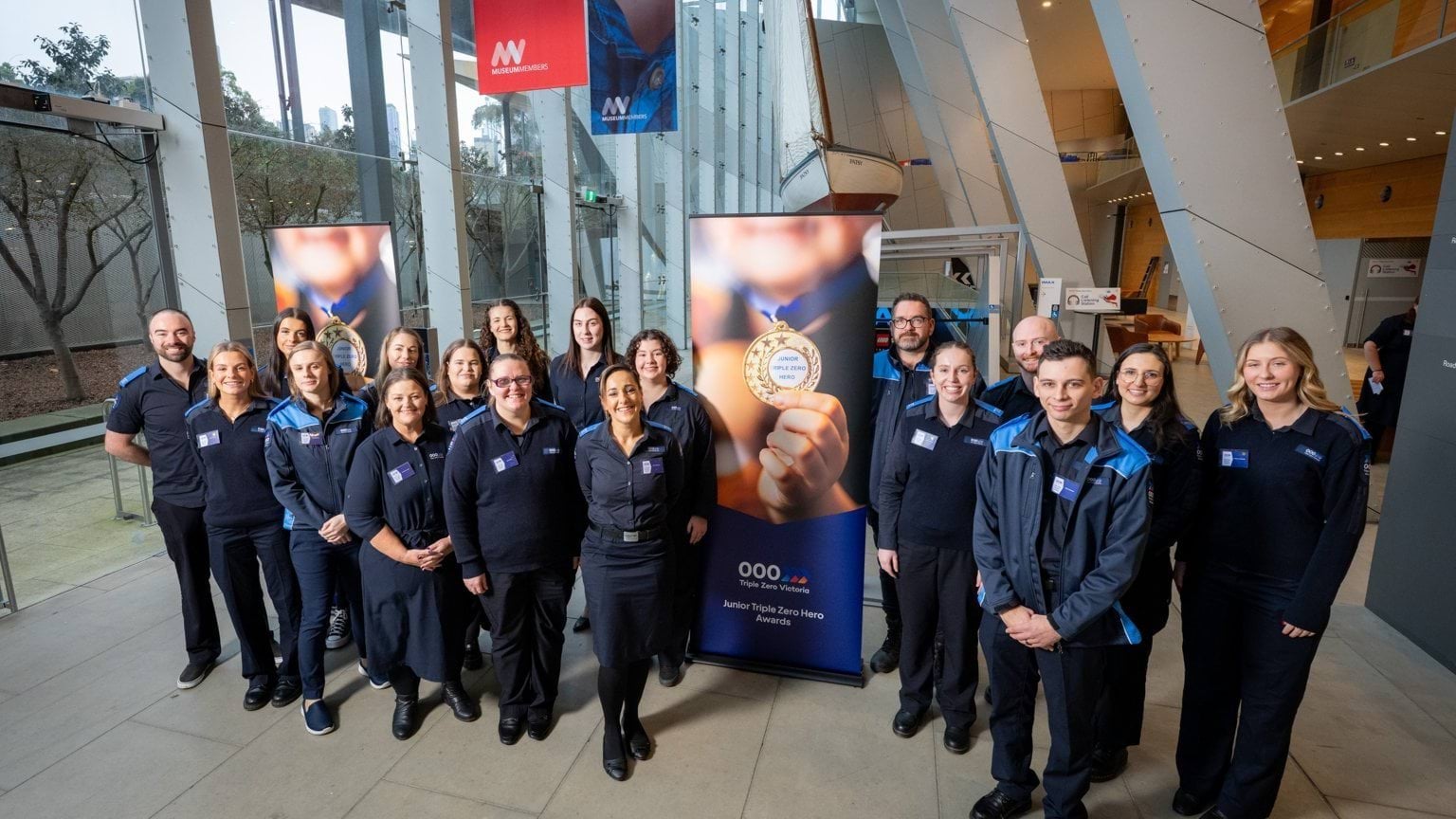 A group shot of the Triple Zero Victoria call-takers who nominated the heroes standing in front of a banner