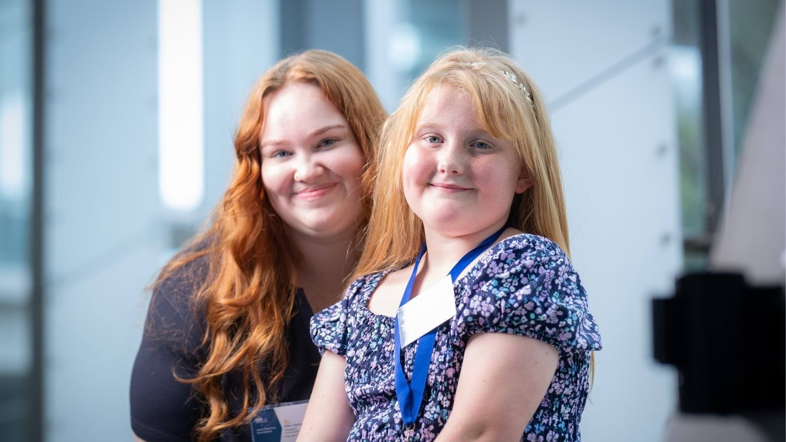 A female Call-Taker sitting with a young girl who was her nominated hero